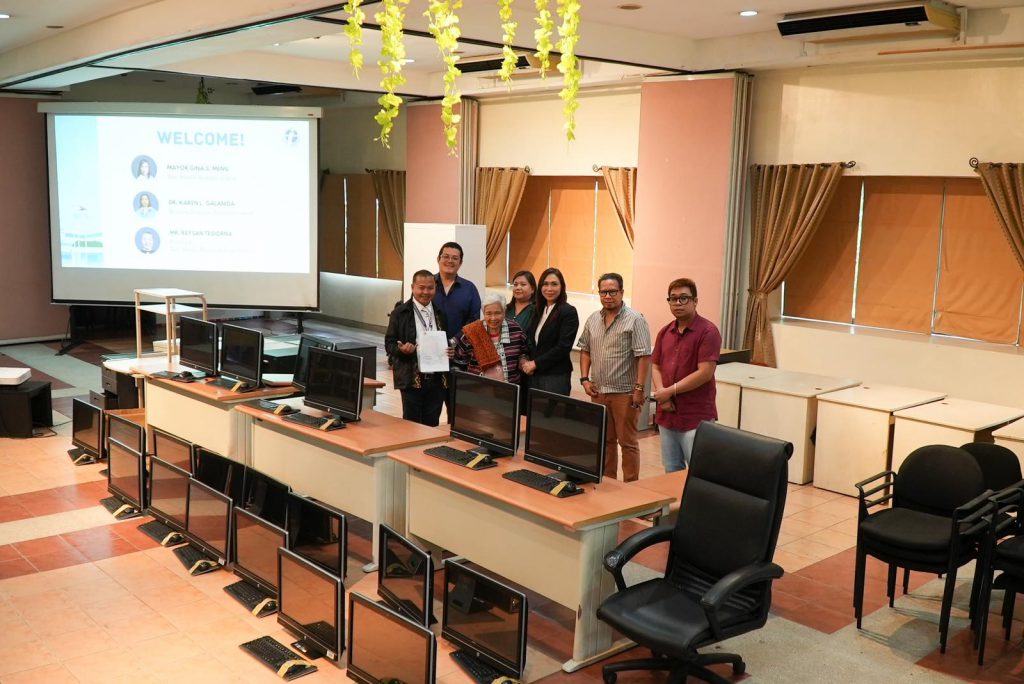 Prof. Leonor Magtolis Briones with San Benito Mayor Gina Menil and San Benito National High School Principal Reysan Tesiorna surrounded with the computer units and office supplies donated to San Benito National High School.